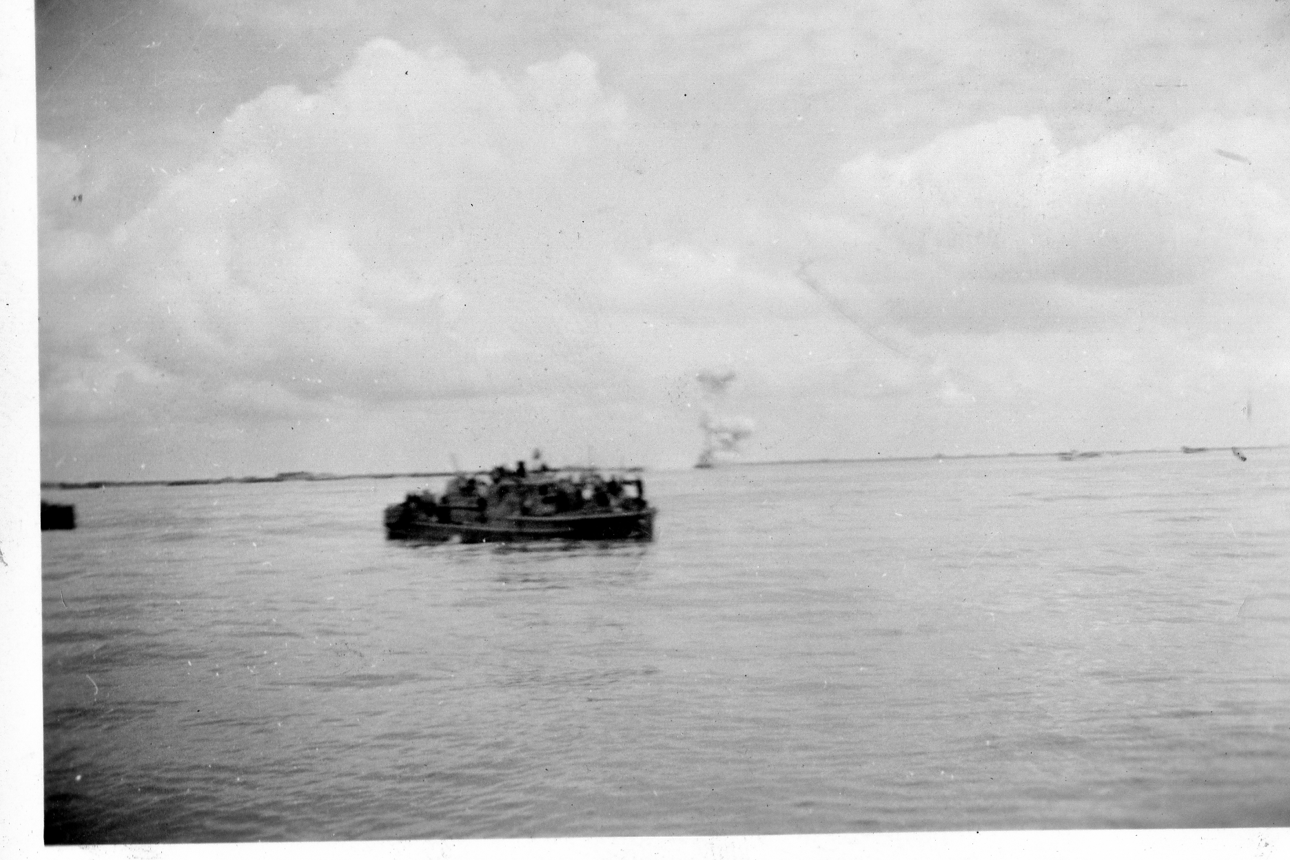 Small German patrol vessel surrendering with destroyer blowing itself up in background.tif